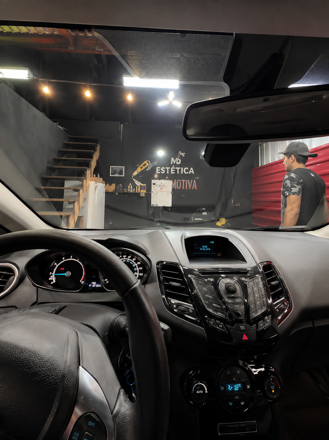 Interior de um carro durante a higienização, visto do banco do motorista